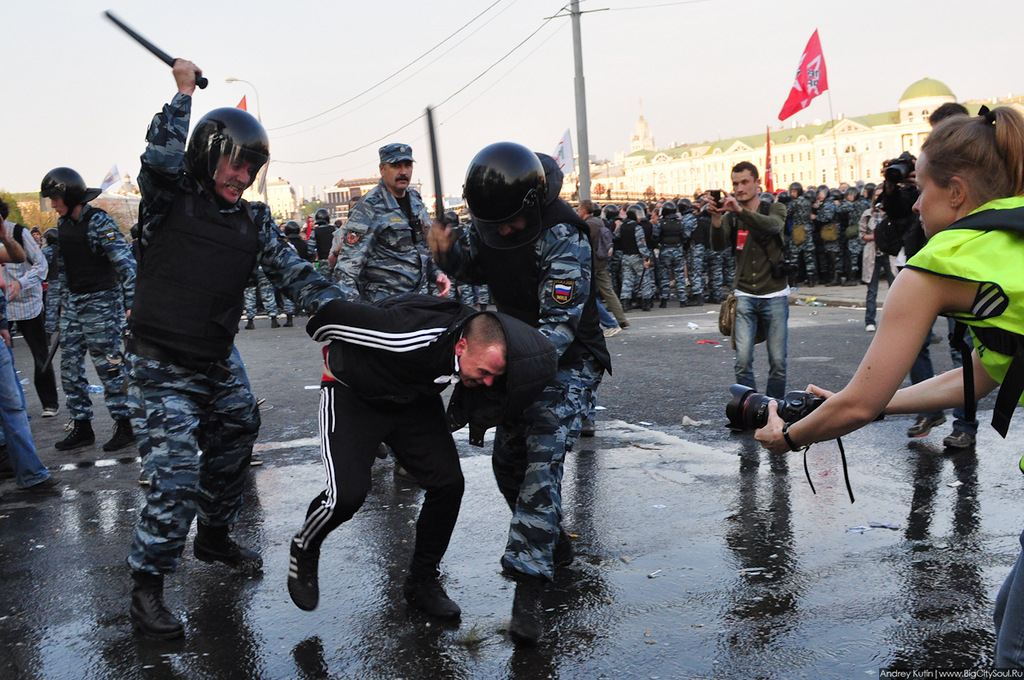 Полиция избила человека. Полицейский бьет дубинкой.