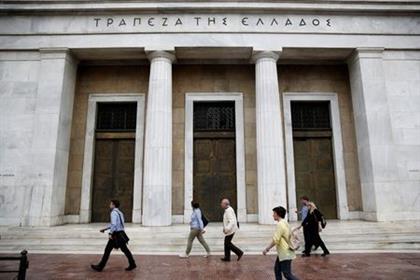 People make their way past the Bank of Greece headquarters in Athens, Greece, May 16, 2017. REUTERS/Costas Baltas 